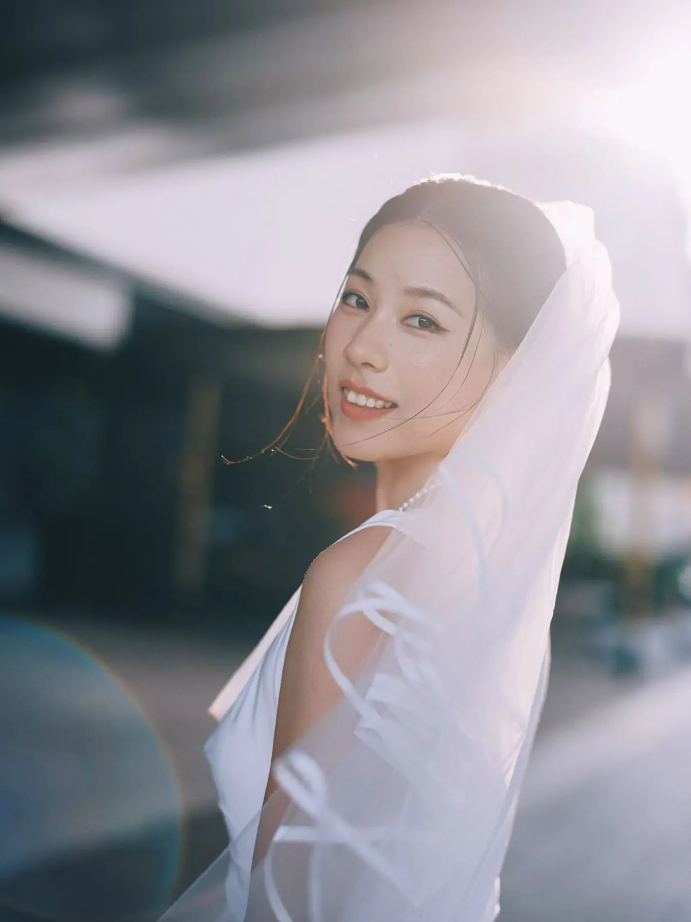 Backlit bridal portrait in a veil by Angelina