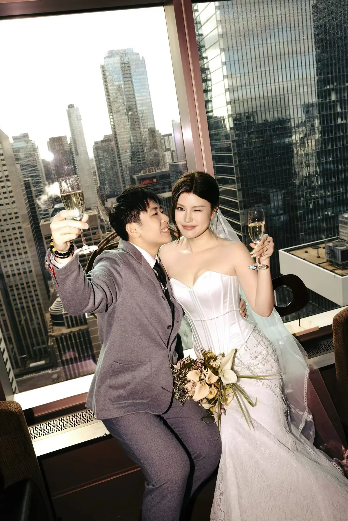 City wedding portrait beside tall windows