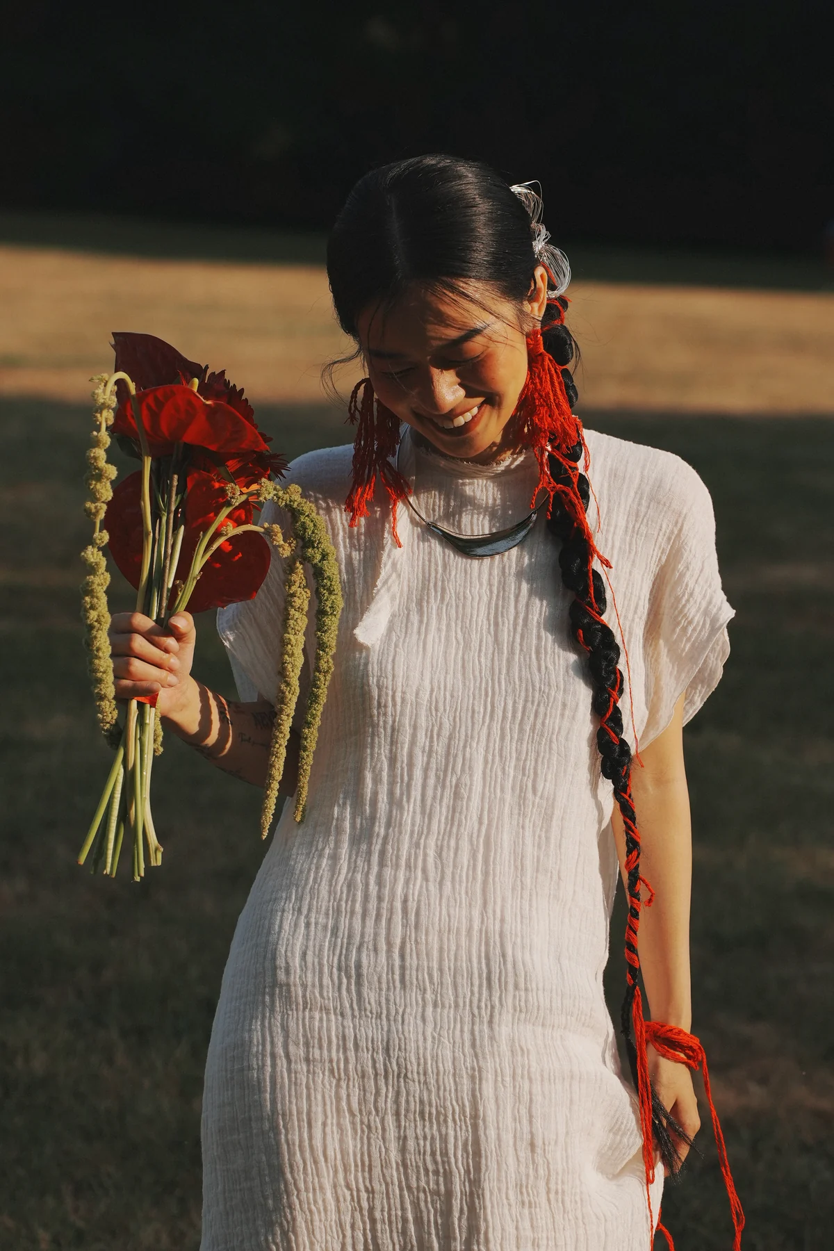 Outdoor bridal portrait with red ribbons and a bouquet