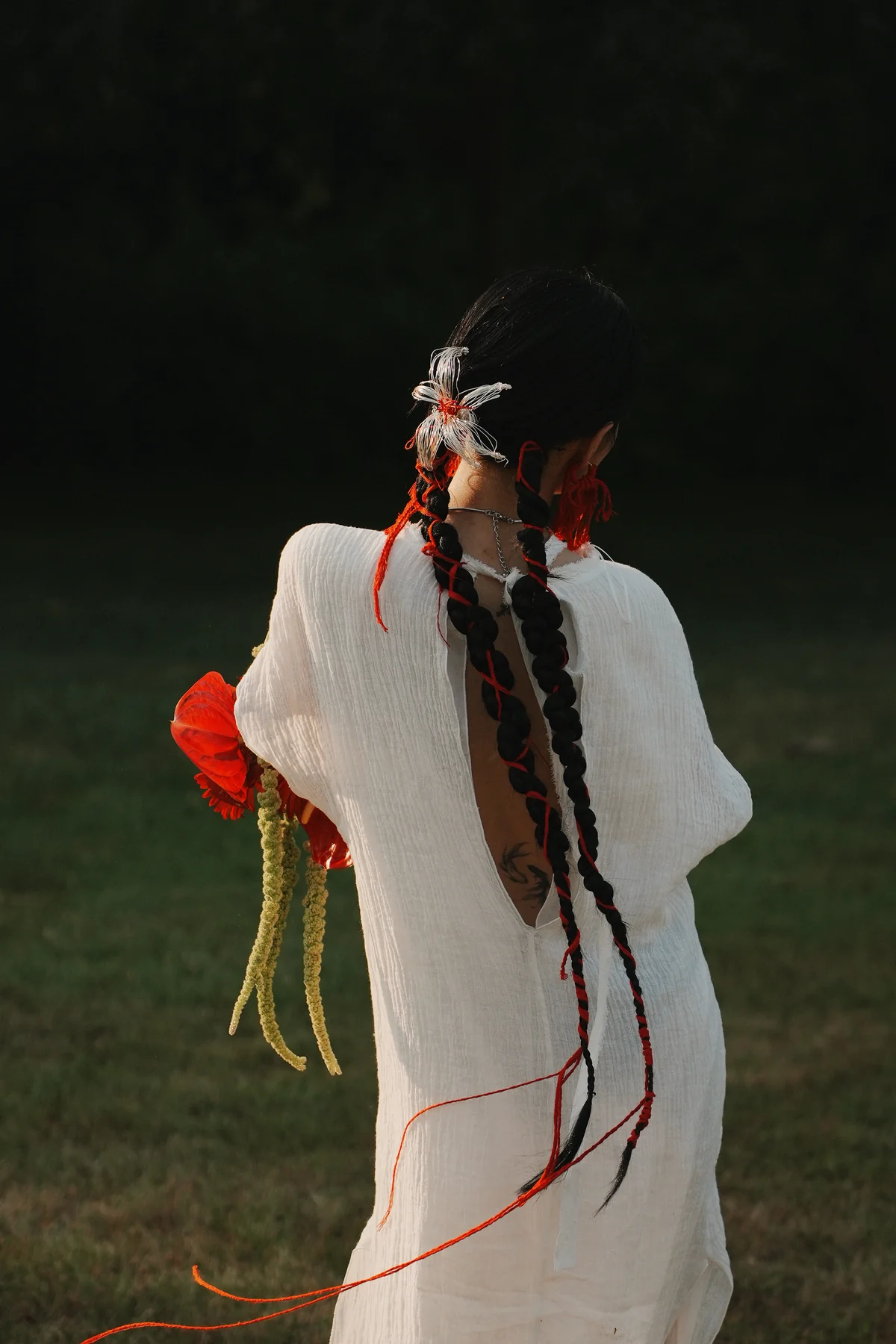 Ribboned bridal hair seen from behind in a garden