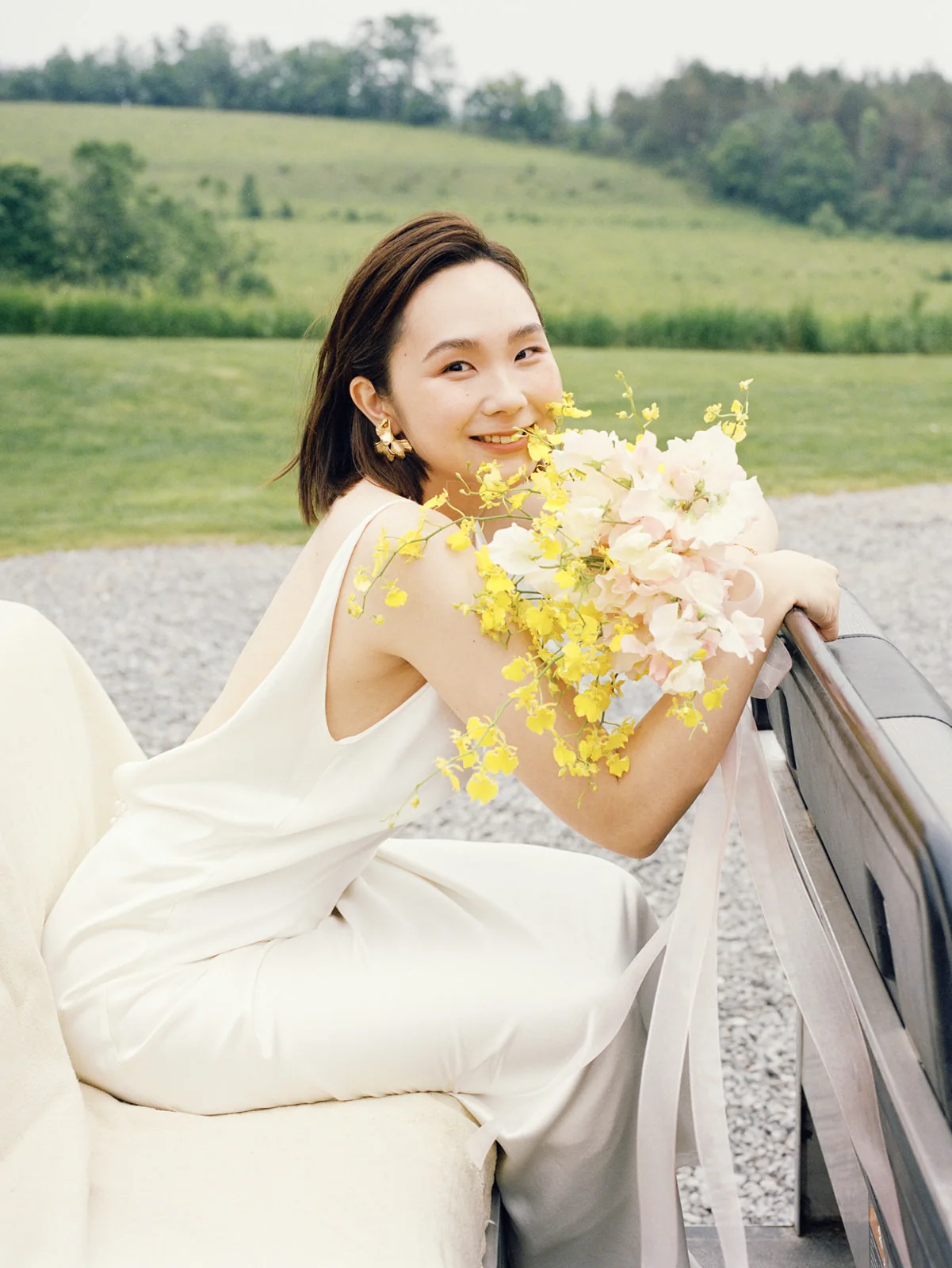 Bride smiling with a yellow floral bouquet