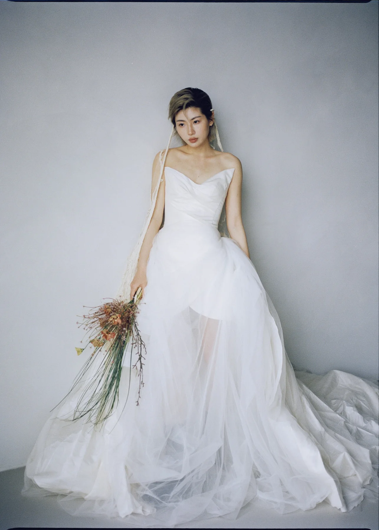 Full-length bridal portrait with a sculptural bouquet
